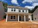 Two-story home featuring a gray exterior, white trim and pillars, and several windows, under a bright sky at 4021 Grommet Ct, Matthews, NC 28105