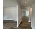A bright hallway featuring hardwood floors and neutral walls leads to other rooms in the home at 4021 Grommet Ct, Matthews, NC 28105