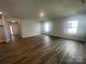 Spacious living room with light gray walls, two windows, and hardwood flooring at 4021 Grommet Ct, Matthews, NC 28105
