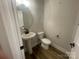Powder room with modern fixtures, wood-look flooring, a pedestal sink and a toilet at 4021 Grommet Ct, Matthews, NC 28105
