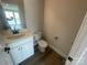 Well-lit powder room with a stylish sink, vanity, and toilet, offering a convenient and elegant space for guests at 4021 Grommet Ct, Matthews, NC 28105