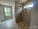 An elegant tiled shower with built-in shelving and a modern shower head offers a luxurious bathing experience at 4021 Grommet Ct, Matthews, NC 28105