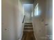 Carpeted stairway with a window and gray walls with white trim at 4021 Grommet Ct, Matthews, NC 28105