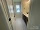 Bathroom view with dark wood vanity, white marble tile flooring, lighting, and fixtures at 4025 Grommet Ct, Matthews, NC 28105
