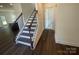 Interior view of the entryway featuring dark wood flooring, a staircase, and a glimpse into the adjacent rooms at 4025 Grommet Ct, Matthews, NC 28105