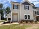 Two-story home featuring stone accents, gray siding, black shutters, and a manicured front yard at 4025 Grommet Ct, Matthews, NC 28105