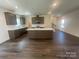 Open kitchen with a central island and bar stool seating, flowing into a bright living area at 4025 Grommet Ct, Matthews, NC 28105