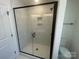 Glass enclosed stand-up shower with white marble tile and black trim at 4025 Grommet Ct, Matthews, NC 28105