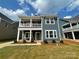 Charming two-story home with a covered porch and balcony, set on a well-maintained lawn under a bright, cloudy sky at 4033 Grommet Ct, Matthews, NC 28105