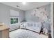 Charming Bedroom with a white crib, floral wall decor, and a cozy rug at 4038 Zilker Park Dr, Charlotte, NC 28217