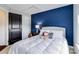 Cozy bedroom featuring a comfortable bed, a striking blue accent wall, and inviting decor at 4038 Zilker Park Dr, Charlotte, NC 28217