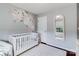 Bright Bedroom showcasing a white crib, floral wall art, and a comfortable, welcoming atmosphere at 4038 Zilker Park Dr, Charlotte, NC 28217