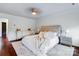 Bright bedroom showcasing a tufted headboard, neutral decor, and hardwood floors at 4038 Zilker Park Dr, Charlotte, NC 28217