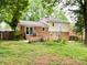 Exterior view of brick home with a partially fenced backyard and a small patio at 4315 Chandworth Rd, Charlotte, NC 28210