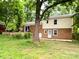 Exterior view of brick home with a partially fenced backyard and a small patio at 4315 Chandworth Rd, Charlotte, NC 28210