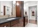 Bathroom vanity with dark cabinets, black countertops, and modern faucet at 435 S Tryon St # 601, Charlotte, NC 28202