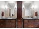 Elegant bathroom with dual vanities, dark cabinets, and matching mirrors at 435 S Tryon St # 601, Charlotte, NC 28202