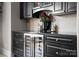 Close-up of a built-in hutch in a dining area, featuring dark cabinets, drawers, a beverage fridge, and a stone backsplash at 435 S Tryon St # 601, Charlotte, NC 28202