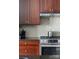 Close-up of a kitchen area with stainless steel stove, oven, and range hood, complemented by dark wood cabinets and backsplash at 435 S Tryon St # 601, Charlotte, NC 28202