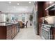Kitchen space with a large island, stainless steel appliances, wood cabinets, and view of the dining area at 435 S Tryon St # 601, Charlotte, NC 28202
