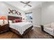 Bright bedroom with a wooden bed frame, ceiling fan, wood flooring, and a sliding glass door to a patio at 435 S Tryon St # 601, Charlotte, NC 28202