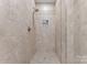 Neutral-colored tiled shower with a glass door and modern fixtures at 435 S Tryon St # 601, Charlotte, NC 28202