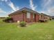 Back exterior view of a brick home with a lush lawn and a wooden deck at 4618 Dallas High Shoals Hwy, Dallas, NC 28034