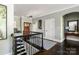 Upstairs foyer showcasing dark hardwood floors, wrought iron railings, and modern decor at 46827 Tall Whit Rd, New London, NC 28127