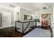 Upstairs foyer featuring dark hardwood floors, wrought iron railings, and a decorative front door at 46827 Tall Whit Rd, New London, NC 28127