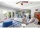 Open-concept living room leading to the kitchen, featuring a stone fireplace and French doors to the deck at 46827 Tall Whit Rd, New London, NC 28127