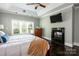 Relaxing main bedroom with a fireplace, tv, hardwood floors, and natural light from a large window at 46827 Tall Whit Rd, New London, NC 28127