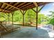 Enjoy the outdoors on the covered patio with wooden beams, chairs, and scenic lake views at 46827 Tall Whit Rd, New London, NC 28127