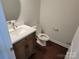 Cozy half bath with a wood vanity, oval mirror, and wood-look floors at 5031 Burnwald Ct, Fort Mill, SC 29715