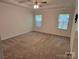 Spacious carpeted bedroom with ceiling fan and two windows for natural light at 5031 Burnwald Ct, Fort Mill, SC 29715