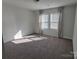 Bright bedroom featuring neutral carpet, two windows with blinds and sheer curtains at 5031 Burnwald Ct, Fort Mill, SC 29715