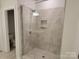 Modern walk-in shower features gray tiling, a glass door, and a built-in niche at 5031 Burnwald Ct, Fort Mill, SC 29715