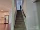 Carpeted staircase with wooden handrail offering a view of the kitchen at 5031 Burnwald Ct, Fort Mill, SC 29715