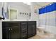 Bathroom featuring a double sink vanity with dark cabinets and a blue shower curtain at 5105 Paisano Ln, Waxhaw, NC 28173