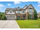 Charming two-story home with stone accents, three-car garage and well-manicured lawn at 5105 Paisano Ln, Waxhaw, NC 28173