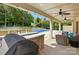 Inviting outdoor living space with a built-in grill, bar seating, ceiling fans, and a view of the pool at 5105 Paisano Ln, Waxhaw, NC 28173