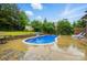 Backyard pool area with lush landscaping and stone retaining wall at 5105 Paisano Ln, Waxhaw, NC 28173