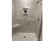Modern shower with tiled walls, a built-in niche, and glass door at 5817 Tuckaseegee Rd, Charlotte, NC 28208