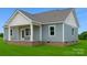 The back exterior with brick foundation, covered porch and lovely blue vinyl siding at 6203 Flay Rd, Cherryville, NC 28021