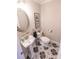Stylish half bathroom with pedestal sink, floral tile flooring, and a decorative mirror at 8005 Island View Ct, Denver, NC 28037