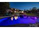 A stunning pool featuring LED lighting reflects the lights of the property's outdoor living space in this twilight image at 8005 Island View Ct, Denver, NC 28037