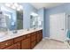 Bright bathroom boasting a double vanity, wood cabinetry, tile floors, and glass shower doors at 8033 Pawleys Ct, Fort Mill, SC 29707
