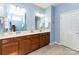 Bright bathroom features a double vanity, wood cabinetry, tile floors, and a well-lit mirror at 8033 Pawleys Ct, Fort Mill, SC 29707