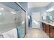 Bright bathroom featuring tile floors, glass door shower, and a vanity with ample counter space at 8033 Pawleys Ct, Fort Mill, SC 29707