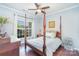 Cozy bedroom featuring a four-poster bed, hardwood floors, and plenty of natural light at 8033 Pawleys Ct, Fort Mill, SC 29707