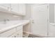 Well-lit laundry room featuring white cabinetry, sink, and access door to outside at 8033 Pawleys Ct, Fort Mill, SC 29707